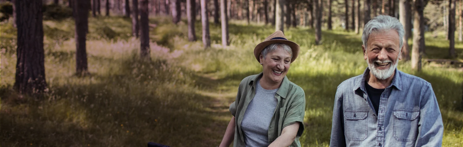 elderly couple walking along forest trail