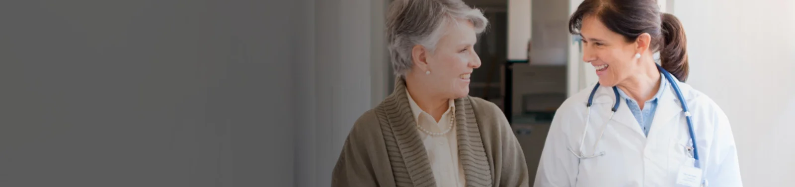 elderly woman and doctor in doctor's office, smiling